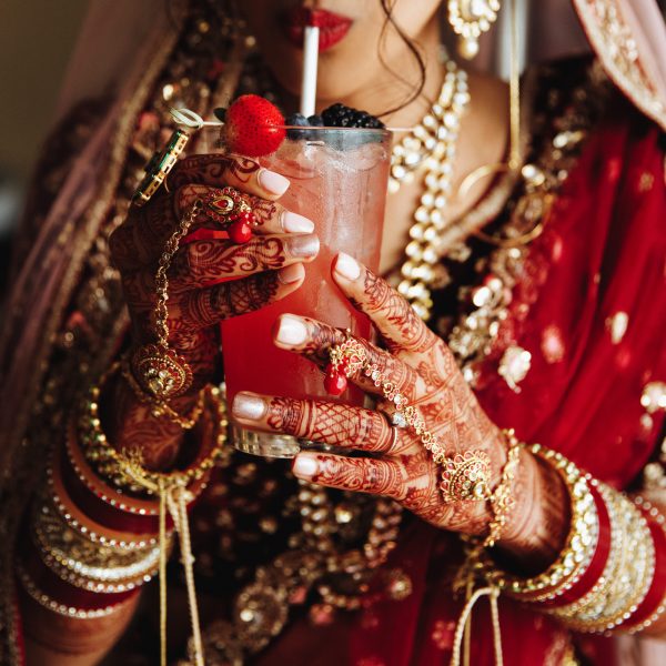 Crop frontview of indian bride is drinkinkg cocktail in traditio Crop frontview of indian bride is drinkinkg cocktail in traditional attire